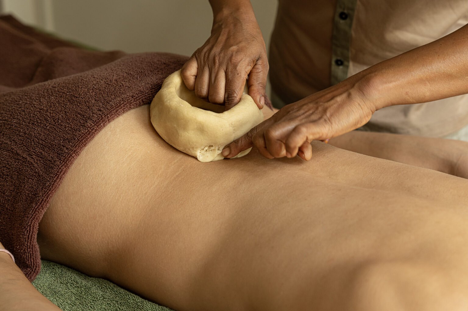 A practitioner carries out a traditional Kati Basti Ayurvedic treatment at Rekawa